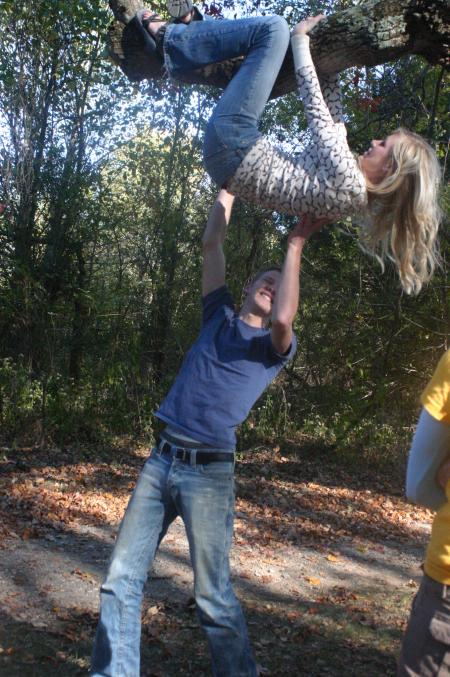 Sophomore Lucas Burke assists Sophomore Tiffany Ransdell in climbing a tree during the art retreat. - Photo by Stephanie Schroeder