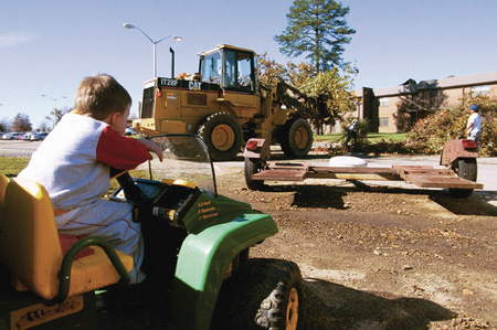 Zachariah Herr, son of McAfee Residence Director Dan
Herr, looks on as cleaning crews haul away trees from the parking lot that were downed by the tornado. - Photo by Justin Veneman