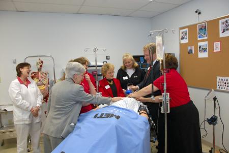 Members of the nursing faculty and staff demonstrate the human patient simulator during the Homecoming reception for nursing students. - Photo by Morris Abernathy