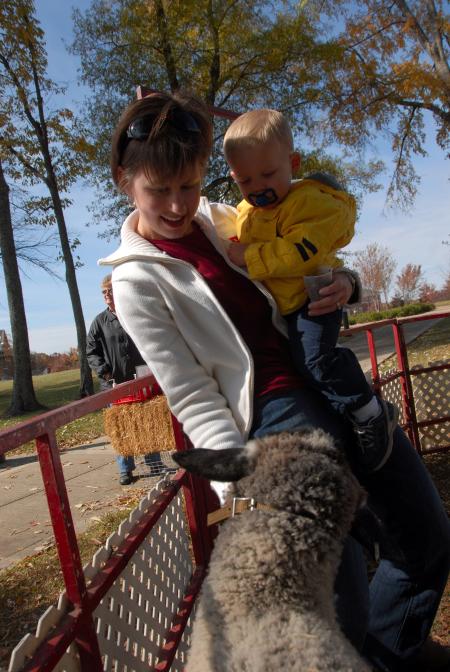 Alum Carrie Wysor and her son enjoy the petting zoo during the Arts in the Park event at Homecoming. - Photo by Morris Abernathy