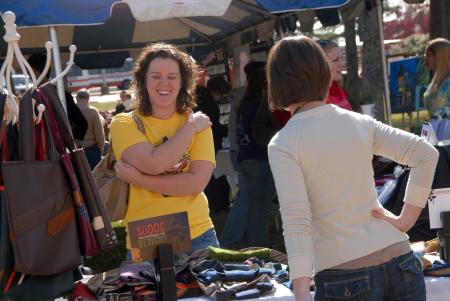 Kim Mills looks over the purses Alum Sarah Dockery was selling at the Arts in the Park event during Homecoming. - Photo by Morris Abernathy