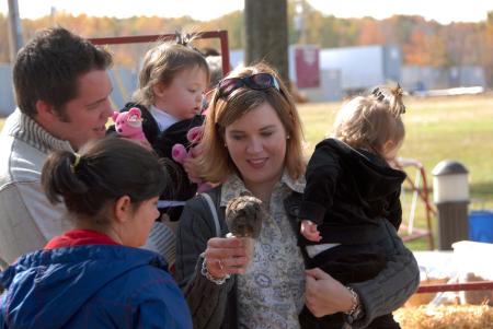 The Morgan Family (Jarred, Jennifer and their daughters Meredith and Mikayla) is distracted by the animals at the petting zoo at the Arts in the Park event during Homecoming. - Photo by Morris Abernathy