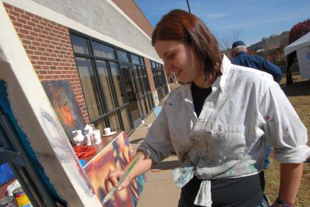 Junior Ruthann Pike paints at the Arts in the Park event during Homecoming. - Photo by Morris Abernathy