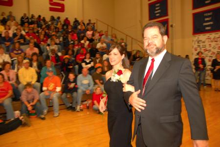 Senior Lindsey Abell, of St. Louis, Mo., music major with an emphasis in Christian studies, who is the daughter of Charles and Mary Abell, is escorted by her father onto the court before the naming of the queen during Homecoming. - Photo by Morris Abernathy