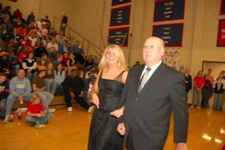 Senior Beth McDowell, nursing major from Cape Girardeau, Mo., who is the daughter of Gary and Donna McDowell, is escorted onto the court by her father before the naming of the queen during Homecoming. - Photo by Morris Abernathy