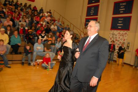 Senior Ashley Cherry, business management and Christian studies major, who is the daughter of Charles and Amy Cherry, is escorted onto the court by her father before the naming of the queen during Homecoming. - Photo by Morris Abernathy