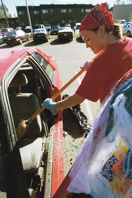 Junior Suzanne Hunt, social work major, began the long process of cleaning out her car after strong winds broke her car windows on Sunday morning. - Photo by Justin Veneman
