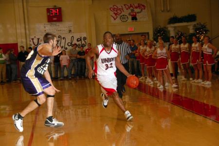 Senior Mack Bealim (32) dribbles the ball down the court during Saturday's Homecoming game versus Olivet Nazarene University (Ill.). - Photo by Morris Abernathy