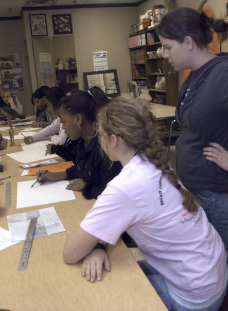 Sophomore Ellen Kay, digital media studies major, and Freshman Allison Forrest, art major, attempt to help the art students with their texture assignments at Jackson Central-Merry High School for the Day of Remembrance.    - Photo by Heather Phillips