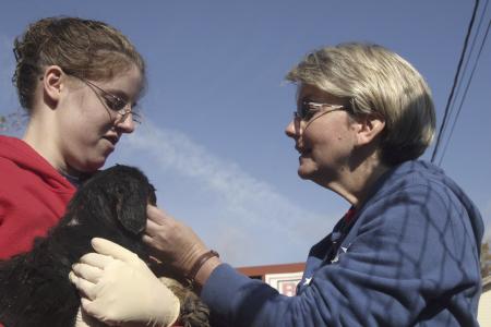 A.J. Gresham and Susan Hopper play with puppies, kittens, and other animals at the Madison County Humane Society during Day of Remembrance. - Photo by Kyle Kurlick