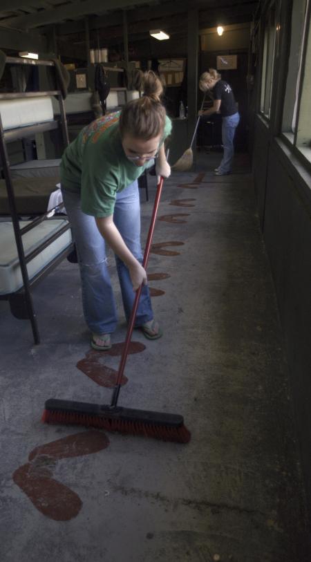 Freshman Ginger Worlay, accounting major, and Sophomore Courtney Sheets, psychology major, sweep the barracks at Youth Town during a Day of Remembrance project.   - Photo by Kyle Kurlick