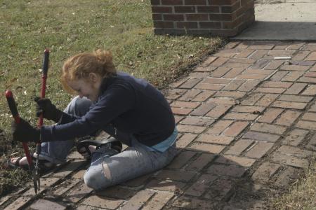 Lily Zopfi weeds out a walkway at The Care Center during Day of Remembrance. - Photo by Kyle Kurlick