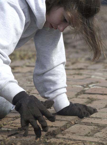 Carolyn Jennings weeds out a walkway at The Care Center during Day of Remembrance. - Photo by Kyle Kurlick