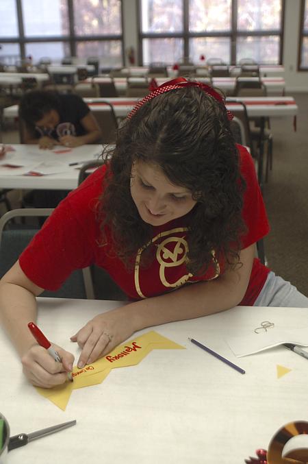 Freshman Mallory Carter, public relations and advertising major, makes decorations at Evangelical Community Church on the Day of Remembrance. - Photo by Holly Gushee