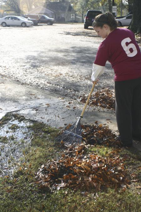 Freshman Sara Beth Woodbury helps out at Alexander Magnet Elementary School by raking tons of leaves on the school property during Day of Remembrance. - Photo by Stephanie Schroeder