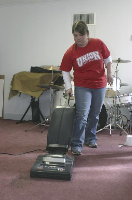 Sophomore Anna Townsend vaccuums the storage room at order to decorate one of the classrooms at Iglesia Bautista Hispania Church located at Poplar Heights Baptist Church during Day of Remembrance. - Photo by Stephanie Schroeder