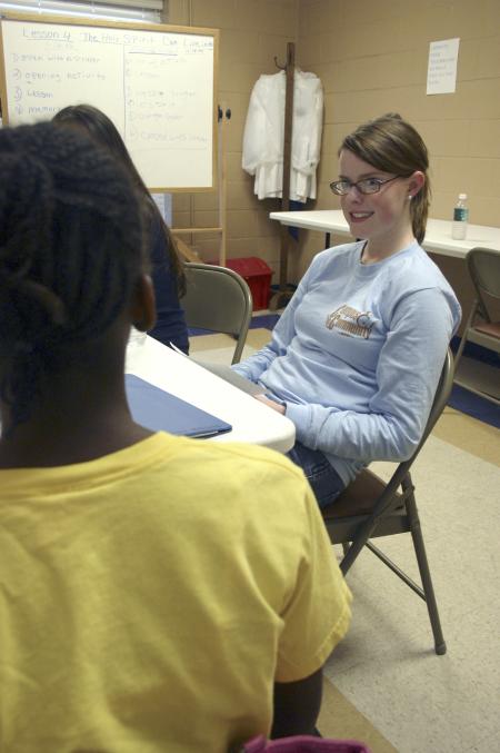 Junior Suzanne Short helps eighth grader Dominique with her homework at The Salvation Army during Day of Remembrance. - Photo by Stephanie Schroeder