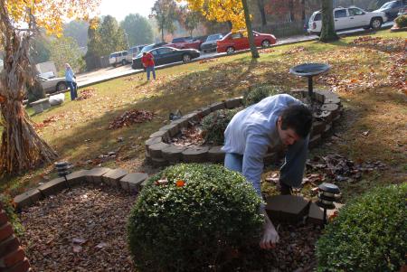 Nick Choate cleans a flower bed at Forest Cove Nursing Home during Day of Remembrance. - Photo by Morris Abernathy