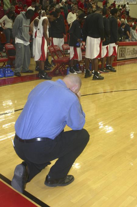 Head Coach Ralph Turner and his players bow their head during the opening prayer for the Bulldogs' Homecoming game against Olivet Nazarene University, Ill. - Photo by Stephanie Schroeder