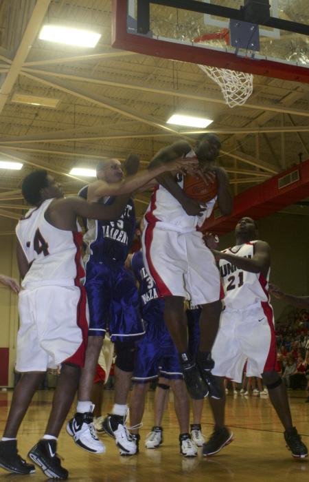 Senior Deywane Lee and Sophomore Brian Lake play defense in order help Pierry Valmera maintain possession of a rebound during the Homecoming game against Olivet Nazarene University, Ill. - Photo by Stephanie Schroeder