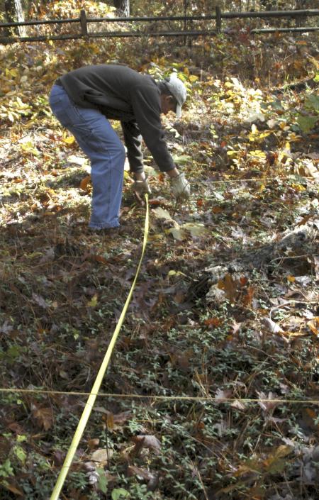 Senior John Crawford, history major, creates a grid to record the ground already checked for buried graves stones at the Ames Plantation during a Day of Remembrance project.  - Photo by Matthew Diggs