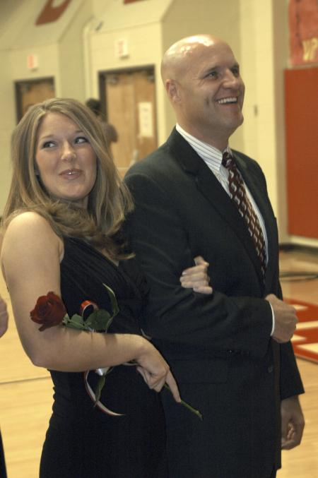 Junior Carolyn Negley, learning foundations major, is escorted off the court by her father during the Homecoming queen ceremony.  - Photo by Matthew Diggs