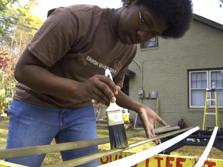 The window wedges at the Young Life house needed painting and who better to do it than SAC President Jande Jackson on Day of Remembrance.  - Photo by Beth Spain