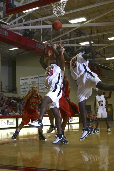 D.J. Sissoko and Josephine Owino jump to grab the ball for a rebound in a game against Georgetown College, Ky. - Photo by Stephanie Schroeder
