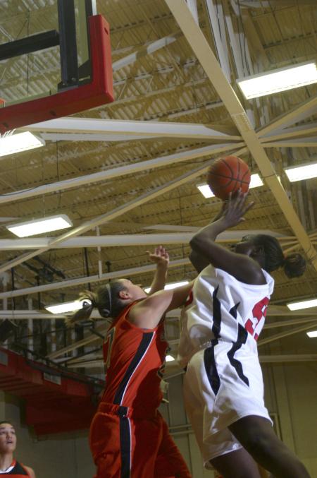 D.J. Sissoko reaches over an opponent for a shot in a game against Georgetown College, Ky. - Photo by Stephanie Schroeder