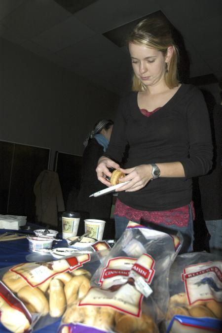 Senior Lauren Crane, journalism major, enjoys a bagel with cream cheese at the senior class' Ode to Bubba's Bagels party.  - Photo by Matthew Diggs