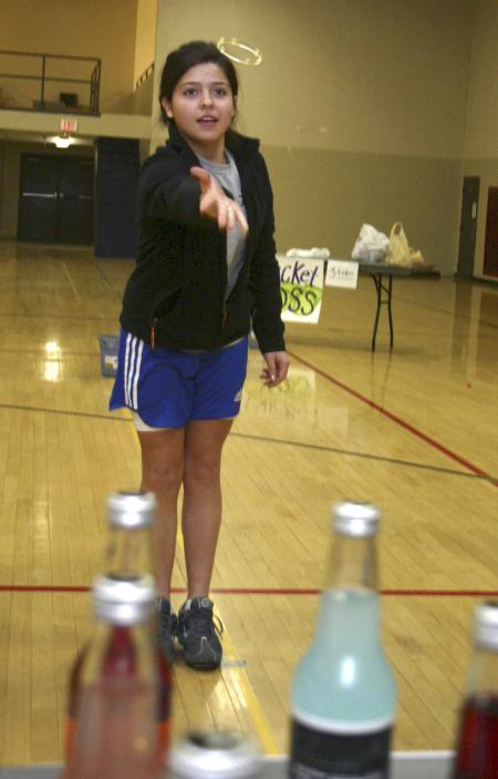Maggie Paredes attempts to land a ring around a bottle for the prize of a can of soda from Jones Soda Co. in a game called Ring around the Jonesy at the carnival held during Frost Fest put on by SAC. - Photo by Stephanie Schroeder