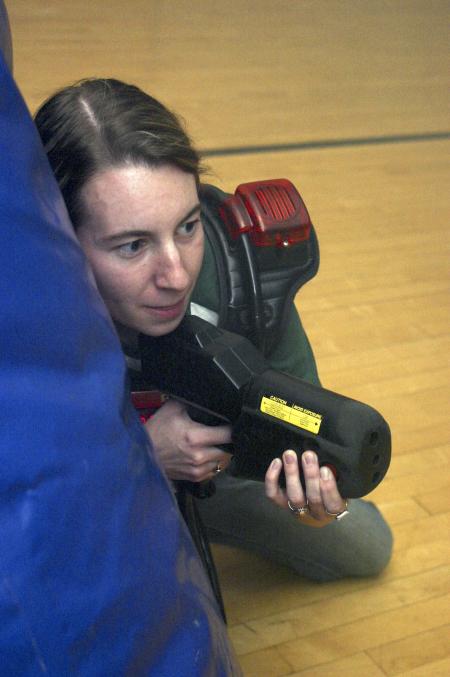 Kasey Cobb guards herself and looks for ways to gain points during a laser tag game held in the small gym during Frost Fest put on by SAC. - Photo by Stephanie Schroeder
