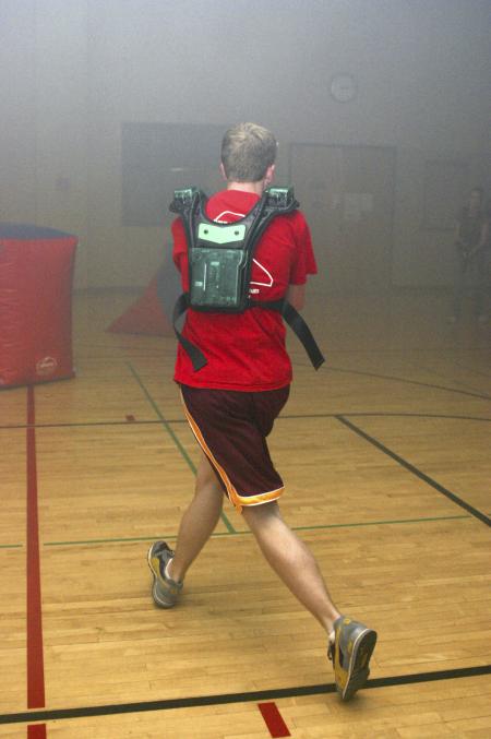 Dustin Mayfield runs for cover and shoots to gain points during a laser tag game held in the small gym during Frost Fest put on by SAC. - Photo by Stephanie Schroeder