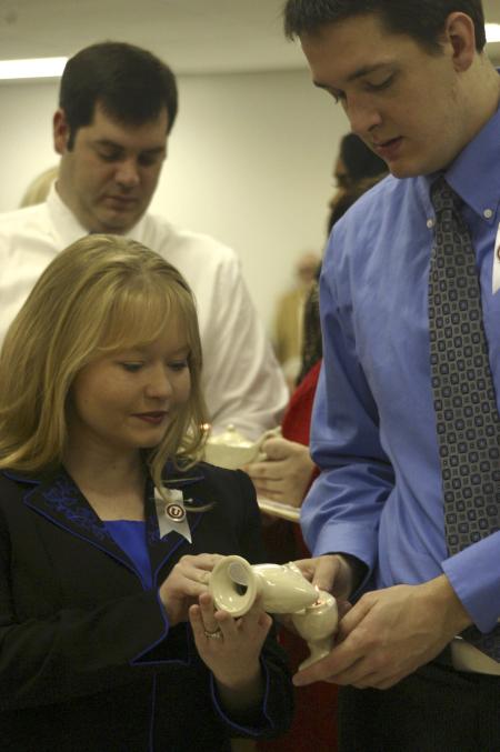 Brittany Brown passes on the lamplight to Joel Brunson as they light the Florence Nightingale candle. Loren Haynes does the same in the background.   - Photo by Stephanie Schroeder