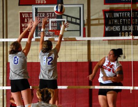 Monica Schirmer, Union senior, hits the ball over the hands of defenders. - Photo by Morris Abernathy