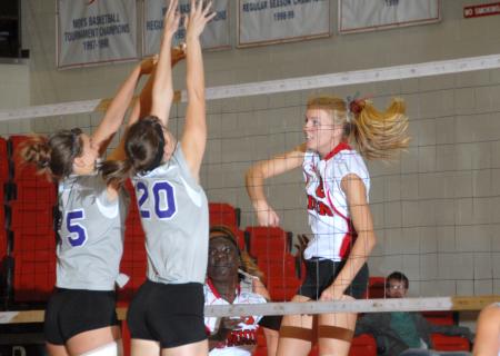 Amanda Hutchison, Union sophomore, spikes the ball over the defenders. - Photo by Morris Abernathy