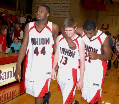 Jeremiah Wade (13) gets contratulated by teammates Pierry Valmera (44) and Brian Lake (21) after his first career game in Union's win over Freed-Hardeman in the conference tournament quarterfinals. - Photo by Morris Abernathy