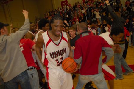 Mack Bealim (32) celebrates with his teammates and the fans after the OT victory over Lambuth in the semi-final game of the TranSouth Tournament. - Photo by Morris Abernathy