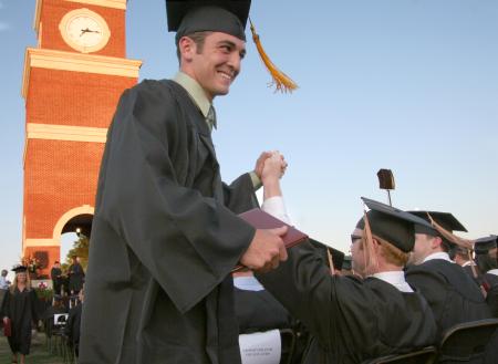 Tyler Porter and Clay Manley high-five each other after receiving their diplomas. - Photo by Kyle Kurlick