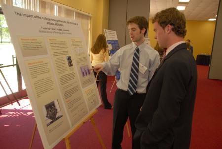 Senior Fred Fisher (left) talks about his poster presentation entitled <em>The Impact of the College Environment on the Formation of Business Students’ Ethical Attitudes</em> in the 2007 Scholarship Symposium. - Photo by Morris Abernathy
