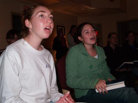 Bets Deere and Ruth Yates sing carols before President Dockery reads the Christmas story in the McAfee Commons. - Photo by Beth Spain