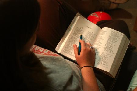 Rising Senior Emily Watkins follows along in her Bible during a Worship Night held in the McAfee commons. - Photo by Stephanie Schroeder