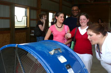 Devon Sledd, Nigel Manuel, Molly Merck and recent graduate Rachel Cooper enjoy a huge fan that provided air in a barn at the home of Professors Keith and Beverly Absher who opened their home for a cookout for the Rising Seniors. - Photo by Stephanie Schroeder