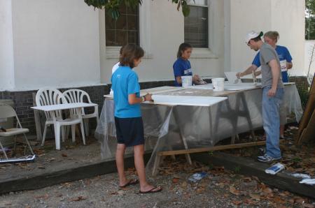 Chelse Lampley, Devon Sledd, Justin Phillips and Victoria Allen paint cabinet doors as part of a Rising Senior project at The Care Center in downtown Jackson. - Photo by Stephanie Schroeder