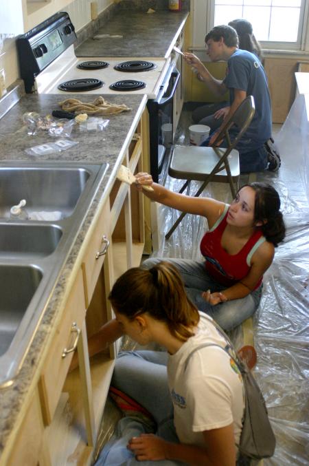 Rising Seniors paint cabinets and doors as part of a project at The Care Center in downtown Jackson. - Photo by Stephanie Schroeder