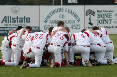 Union players kneel for prayer prior to the start of their games. - Photo by Steven Aldridge