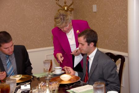 First Lady Lanese Dockery demonstrates an eating technique with Senior Landon Preston during Career Services' Etiquette Luncheon. - Photo by Morris Abernathy