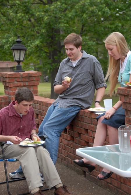 Matt Kuchem, Tyler Whetstone and Racheal Presnell enjoy food at the home of David and Nan Thomas. - Photo by Morris Abernathy