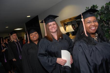 Smiling graduates prepare to march into the August graduation ceremony. - Photo by Morris Abernathy