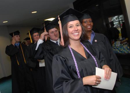 Smiling graduates prepare to march into the August graduation ceremony. - Photo by Morris Abernathy